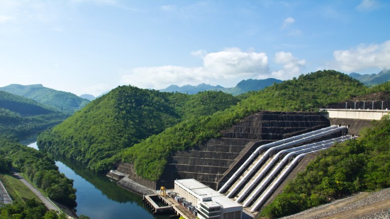 A view from the top of the rock-fill dam of the Srinakarin pumped storage hydroelectric power plant in the Kanchanaburi province of Thailand, built on the river Kwai. On the right we can see the penstocks. (Source: © markuso / stock.adobe.com)