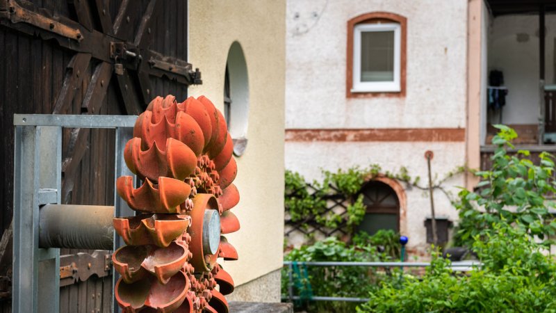 Old orange Pelton turbine runner as an outdoor decoration. (Source: © Stefan / stock.adobe.com)