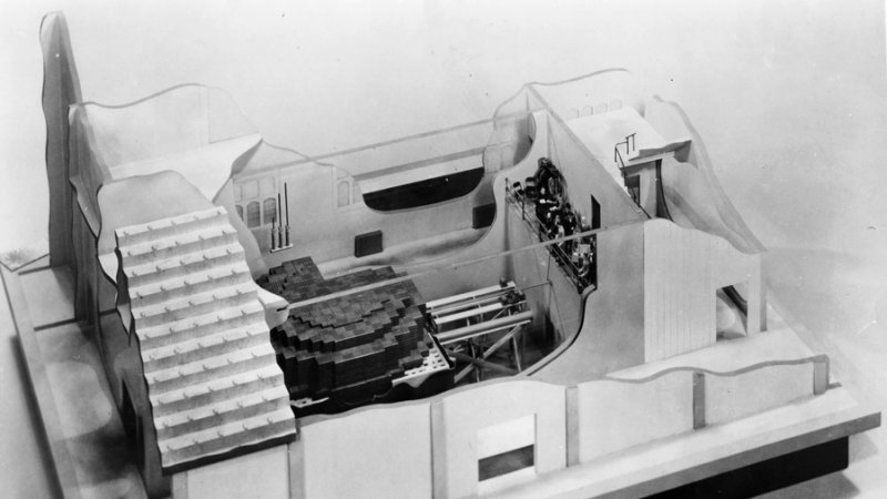 A photograph of the first nuclear reactor. A group of scientists on the balcony records the first manmade fission chain reaction. The reaction was terminated after 28 minutes by insertion of a cadmium rod into the reactor. (Archival Photographic File, [apf2-00504r], Special Collections Research Center, University of Chicago Library.)