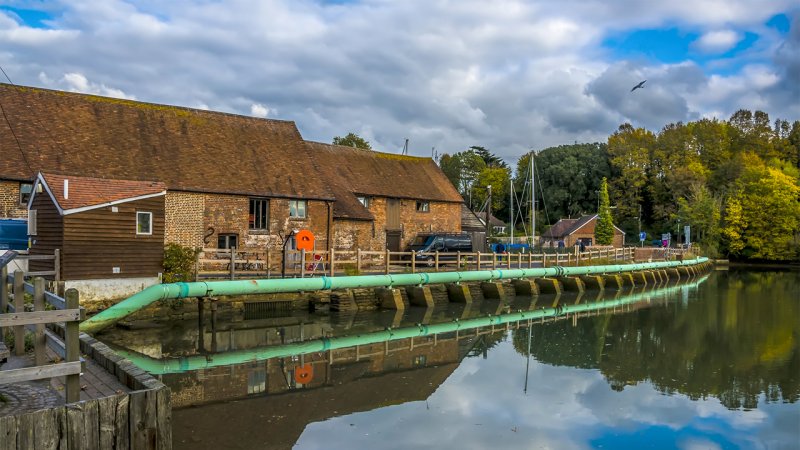 The only water mill in Eling, England, that is driven by water impounded in a pool at high tide. During ebb tide water is run through a water wheel back into the bay. (Source: © Nicola / stock.adobe.com)