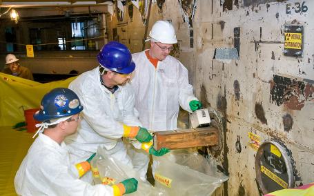 Workers dismantling control rod guide tubes from the biological shielding of the Brookhaven Graphite Research Reactor during the decommissioning process. (Source: Wikipedia.org)