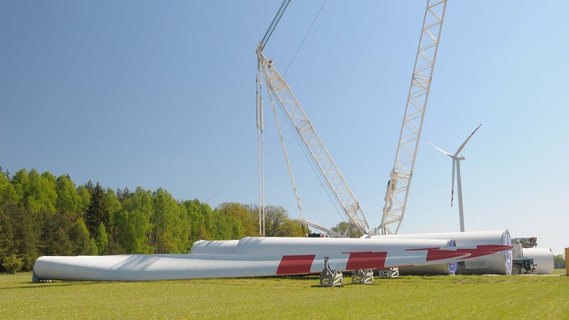 Rotor blades tower segments awaiting construction using a specialized crane. (Source: © luiggi33 / stock.adobe.com)