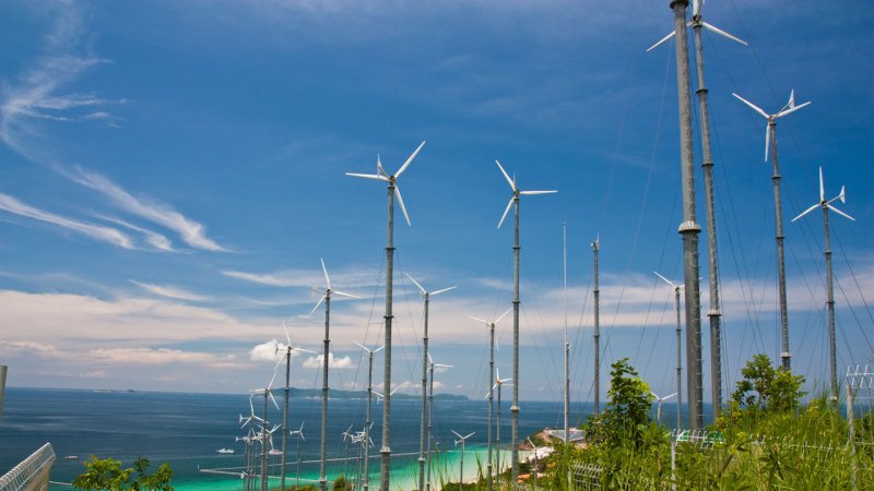 Small wind turbines at the foot hills of the Lan Island, near the city of Pattaya, Thailand. (Source: © Surachai / stock.adobe.com)