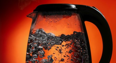 Why does water in a kettle bubble before it reaches the boiling point (90° +) and when the kettle turns off and the thermometer reads 100 °C, it no longer does?