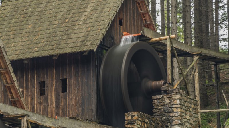 A rotating overshot water wheel in an outdoor display of a museum. (Source: © luzkovyvagon.cz / stock.adobe.com)
