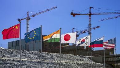 The flags of the seven ITER Members — China, the European Union, India, Japan, Korea, Russia, and the United States — fly over the worksite. (Credit © ITER Organization, www.iter.org)