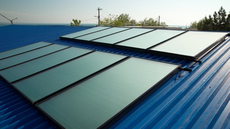 Attaching the solar collectors to the roof, before connecting them to the water circuit. (Source: © Pavlo Vakhrushev / stock.adobe.com)