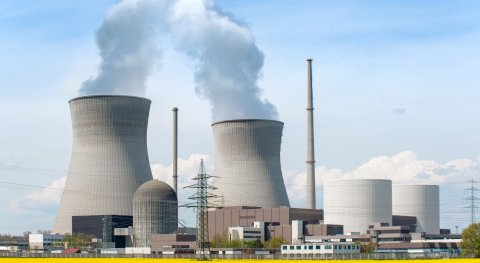 What are the costs of building, operating, and decommissioning a nuclear power plant versus the profit from selling the electricity and heat produced?