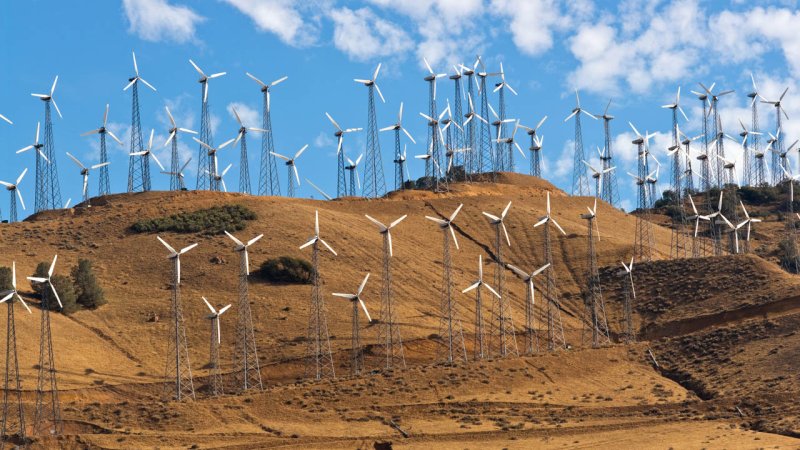 A wind farm with a large number of wind turbines situated on a mountain ridge with favorable wind conditions. (Source: © BVDC / stock.adobe.com)