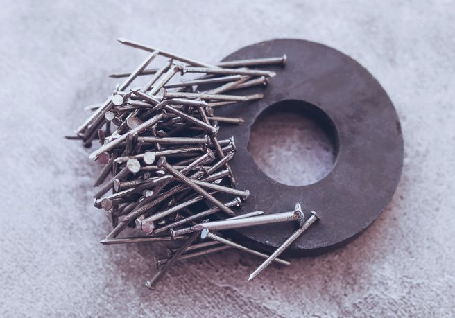 Ferromagnetic iron nails attracted to round magnet. (Source: © Tatyana / stock.adobe.com)